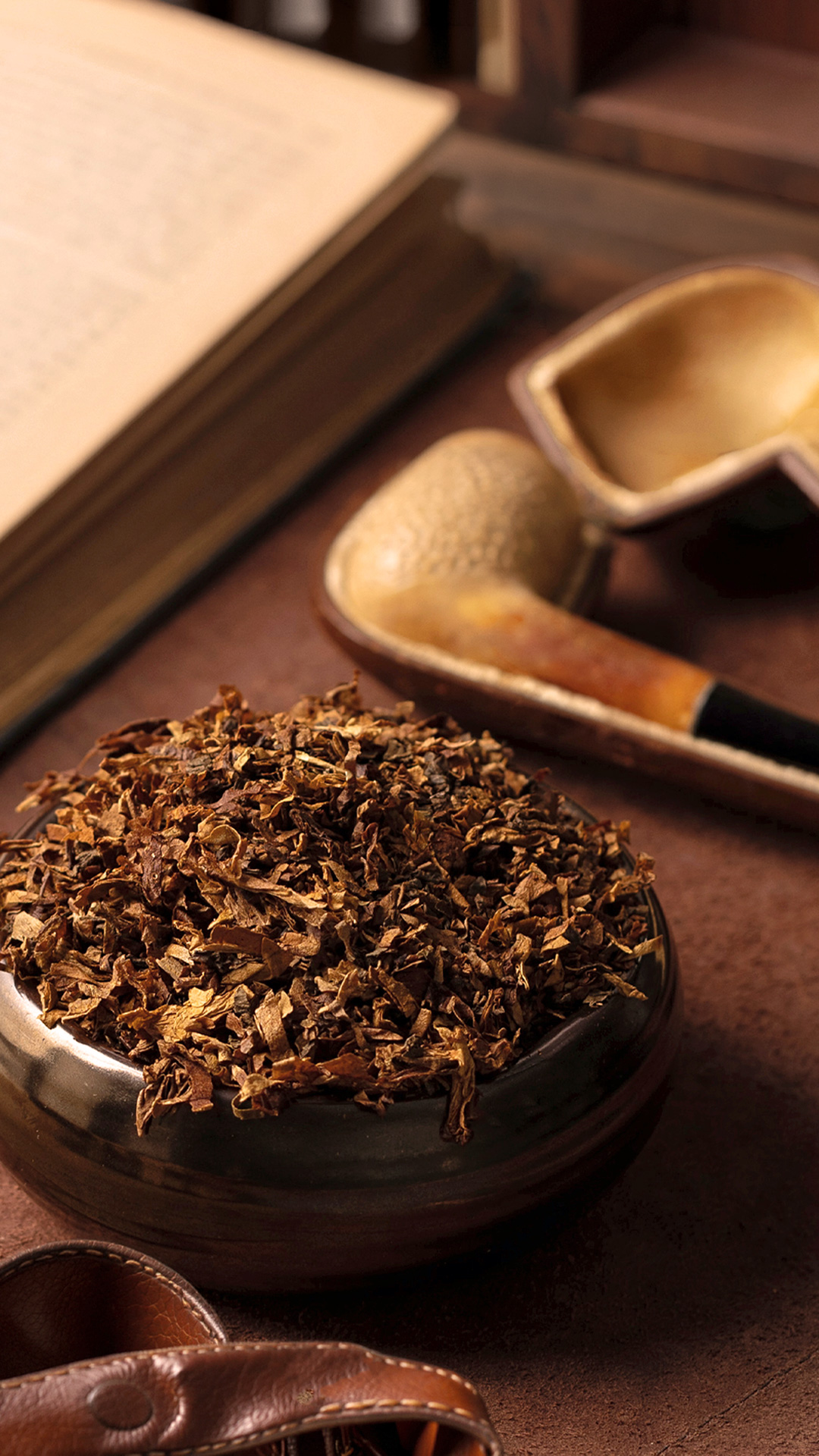 A bowl of loose-cut Bayou Morning pipe tobacco beside a pipe and open book